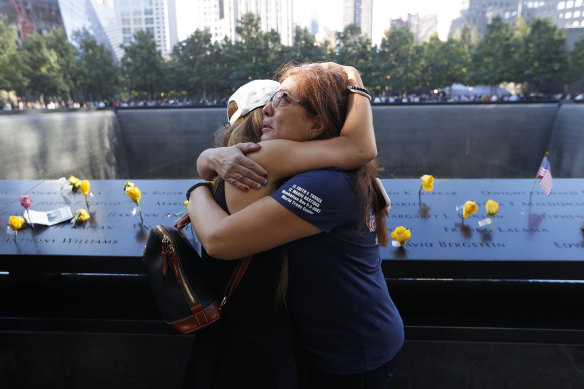 Melinda Moran and Haydee Lillo embrace after finding out they lost people who knew each other, next to the North Reflecting Pool during a ceremony at the National September 11 Memorial & Museum in New York.