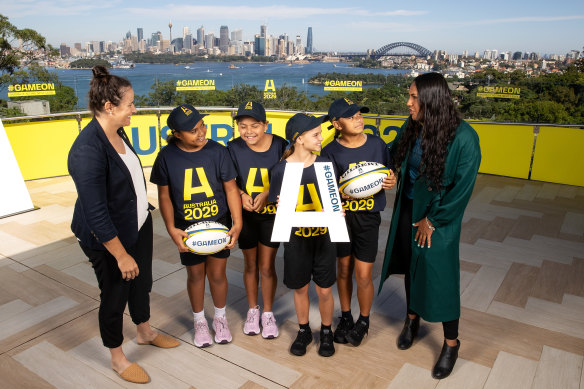 Wallaroos Shannon Parry (l) and Mahalia Murphy (r) pose with members of the Randwick Magic junior rugby team.