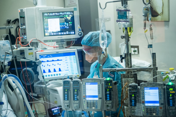 An ICU nurse treats a coronavirus patient at the Austin.