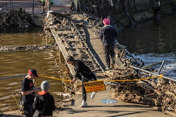 Locals inspect the flooded foreshore.