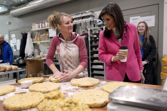 Republican presidential candidate former UN Ambassador Nikki Haley, right, greets Kim Morgan as Morgan makes scones after a campaign event at The Bread Board in Pella, Iowa.