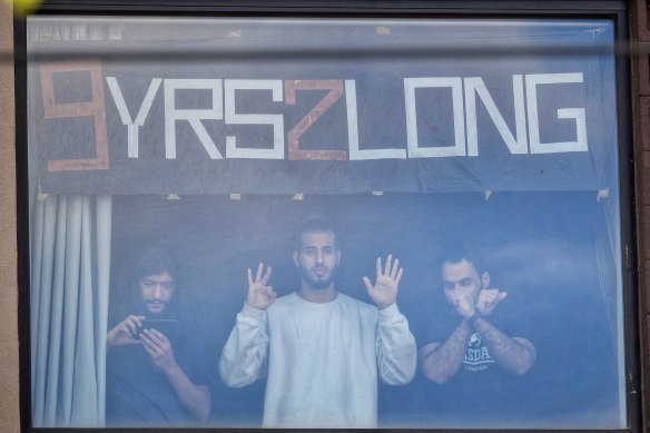 Refugees at the Park Hotel including Mehdi (left) watch the protests on the street during Djokovic’s detention. 