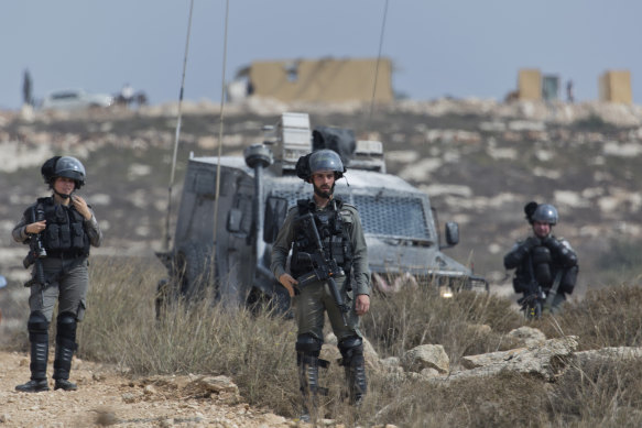 Israeli border police secure a road leading to a newly established Israeli settlers outpost, seen in the background, during clashes with Palestinian protesters in the West Bank village of Tormusayya, last month.