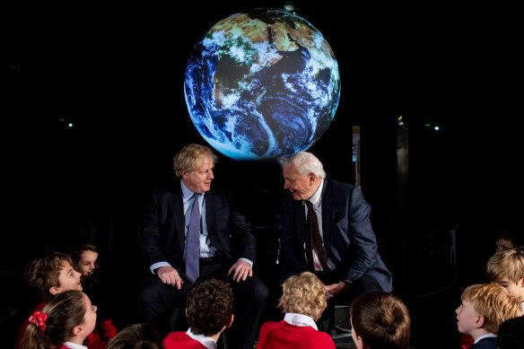 British Prime Minister Boris Johnson and broadcaster and naturalist Sir David Attenborough speak with schoolchildren during the launch of the UK-hosted UN Climate Summit in Glasgow.