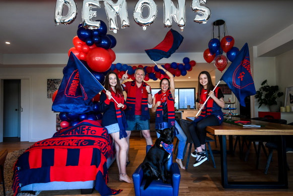 Trav and Meg Rankin with kids Emily (left), Lucinda (right) and dog Stella in Melbourne colours ahead of the grand final. 