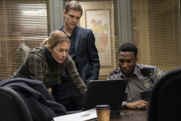 Mare Sheehan (Kate Winslet) and Colin Zabel (Evan Peters, standing) investigate the death of a teen, who may or may not be the victim of a serial killer.