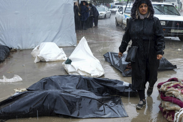 A woman walks between dead bodies of Palestinians killed in the Israeli bombardments of the Gaza Strip, in front of the morgue at Al Aqsa Hospital in Deir al Balah, Gaza Strip, on Sunday.