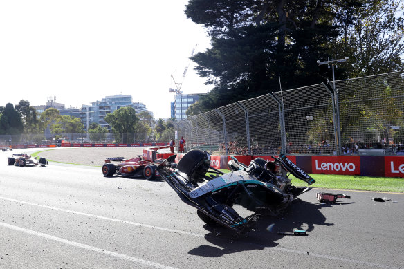 George Russell waits in his upturned Mercedes after the crash in the closing stages of the Australian Grand Prix on Sunday.