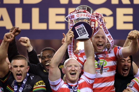 Liam Farrell of Wigan Warriors lift the trophy following victory.