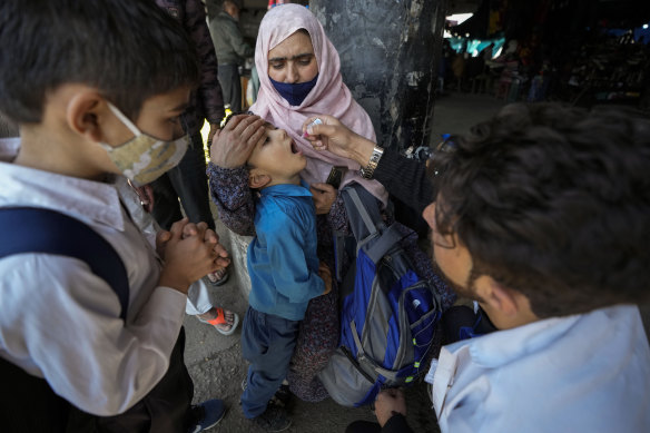 A medical volunteer administers a polio vaccine to a child at a bus station in Jammu, India.