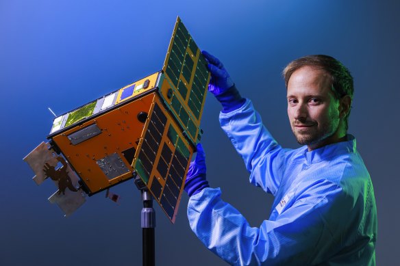 Melbourne University electronic engineer Miguel Ortiz del Castillo with a scale model of the SpIRIT nano satellite.