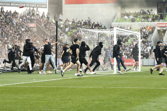 Fans invade the pitch during a Melbouren derby in December.