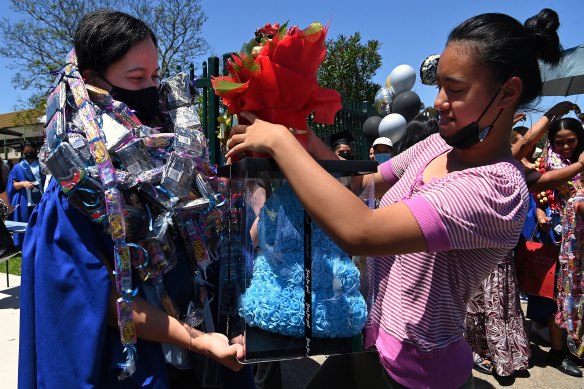 Canley Vale High School HSC student Neryhetta Tuisalega (left) receiving gifts and celebratory chocolate garlands moments after graduating from Canley Vale High School.