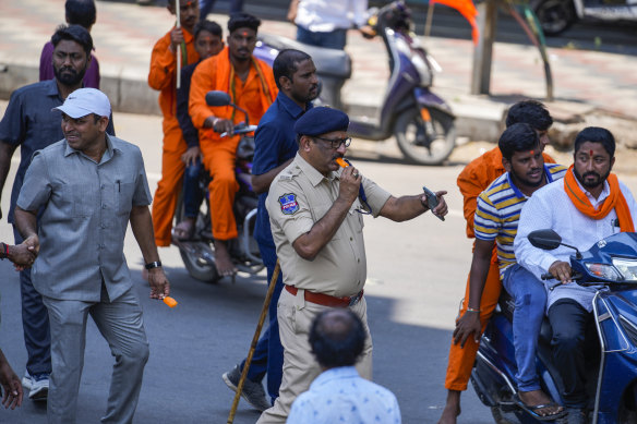 A policeman takes an icy pole to beat the heat as he directs traffic during a Hindu religious procession to mark Hanuman Jayanti festival in Hyderabad, India, last week.