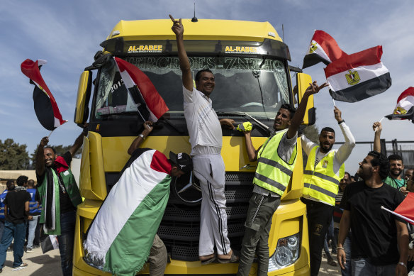 Volunteers and NGO staff celebrate after unloading aid supplies and returning to the Egyptian side of border near Rafah, in North Sinai, Egypt.