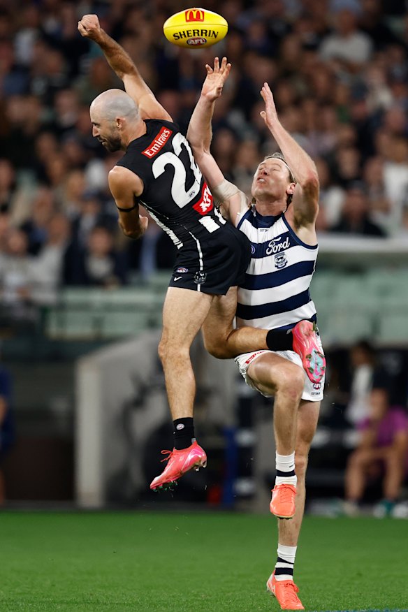 Steele Sidebottom of the Magpies and Mark Blicavs of the Cats compete for the ball.