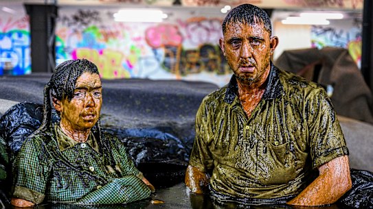 Down and dirty: Angus Cerini and Nicci Wilks perform part of THIS in a pool of mud.