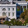 Construction workers, bottom right, atop the U.S. Treasury, watch as work continues on a largely demolished part of the East Wing of the White House, Thursday, Oct. 23, 2025, in Washington, before construction of a new ballroom. (AP Photo/Jacquelyn Martin)