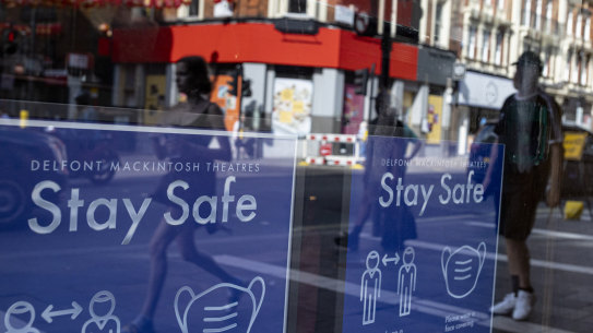 Coronavirus safety posters are displayed in the window of the Sondheim Theatre, London. The city is extended coronavirus restrictions over the Delta variant.