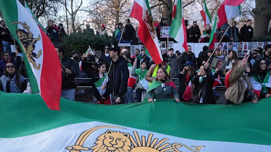 As reuniões tornam-se globais: manifestantes manifestam-se em Londres carregando a tradicional bandeira do Irão pré-República Islâmica.