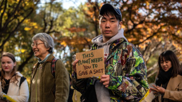 A protester holds a placard as he takes part in a Global Climate Strike protest in Tokyo on Friday.