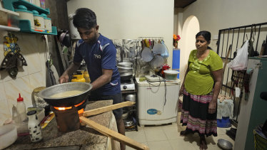 A mother and son cook with firewood at their home in Colombo.