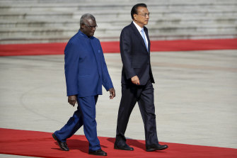 Solomon Islands Prime Minister Manasseh Sogavare, left, walks with Chinese Premier Li Keqiang in October 2019. 