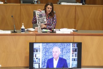 Commitee chair Senator Sarah Hanson-Young holds up a front page of the Daily Telegraph as she puts a question to former Prime Minister Malcolm Turnbull as he appears via videoconference during a hearing on media diversity in Australia at Parliament House in Canberra.