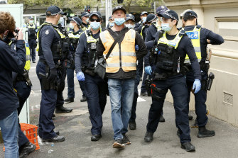 Police detain a man at the corner of Elizabeth and Victoria streets near the CFMEU head office.