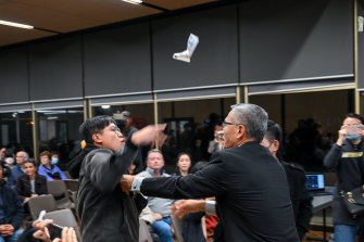 Hong Kong independence activist Max Mok is tackled by forum organiser Jimmy Jian-Min Li.