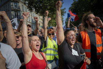 Anti-vaccine demonstrators chant through the streets of Paris.