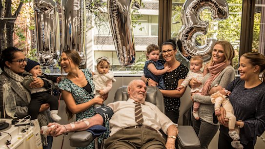 James Harrison (centre), surrounded by mothers of Anti-D babies at his final donation. 
L-R: Christine Damiandis and Georgio, Michelle Dibbs and Eloise, Tanya McLaren and Brianna, Sarah Doyle and Grace