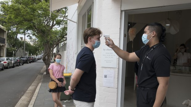 Shoppers have their temperature taken before entering a jewellery store in Paddington.
