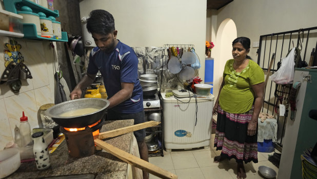 A mother and son cook with firewood at their home in Colombo.