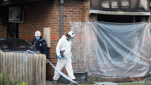 Forensic police and fire crews inspect the remains of a house which burnt down in Eames Avenue.