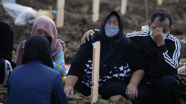 Family members weep during the burial of a relative at Jakarta’s Rorotan Cemetery which is reserved for those who die of COVID-19.