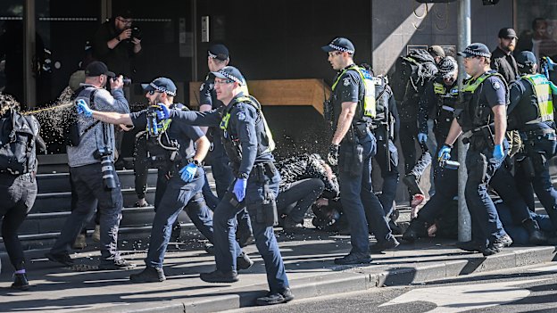 Police officers use capsicum spray during a demonstration in Melbourne’s CBD last Saturday.