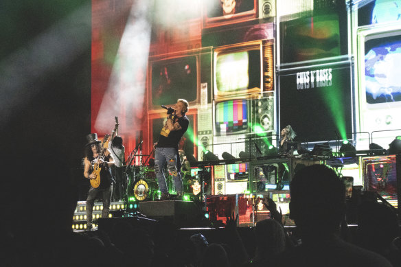 Slash (left) shreds and Axl Rose (centre) shrieks at Accor Stadium on November 27.