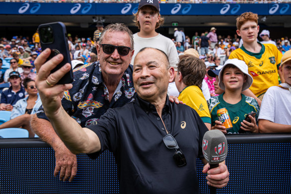 Eddie Jones poses for a selfie with a fan. 