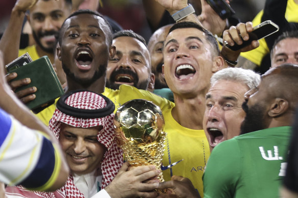 Al Nassr’s Cristiano Ronaldo and teammates celebrate with the trophy of the Arab Club Championship Cup.