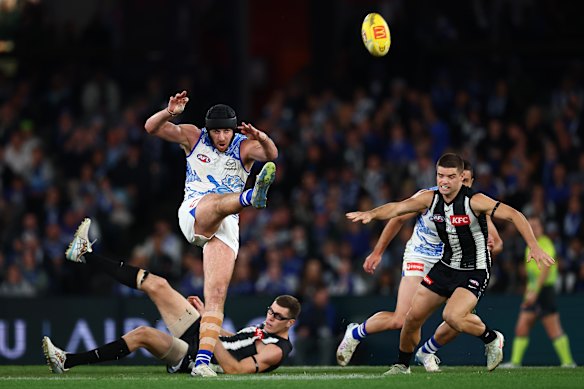 Tristan Xerri of the Kangaroos kicks the ball.