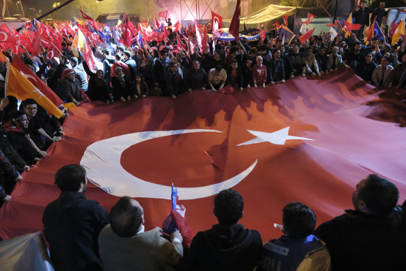 Recep Tayyip Erdogan supporters wave flags and chant slogans as they celebrate the presidential election victory.