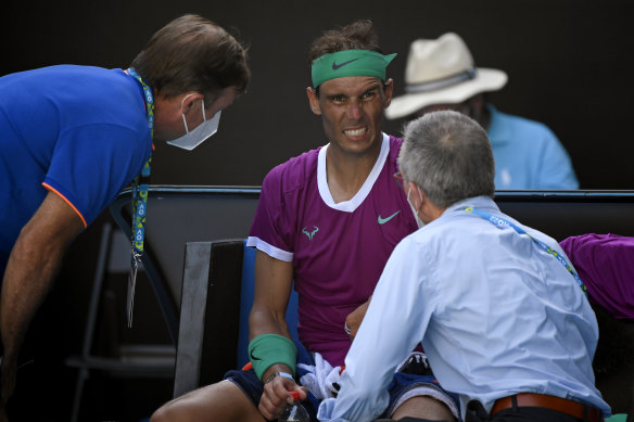 Rafael Nadal talks to medical staff during a break in the quarter-final clash.
