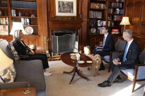 The ambassador explains what a “shitbox rally” is to her interviewers, Matthew Knott (centre) and Peter Hartcher (right). Labradoodle Chester listens in. Pictured at the US embassy in Canberra. 