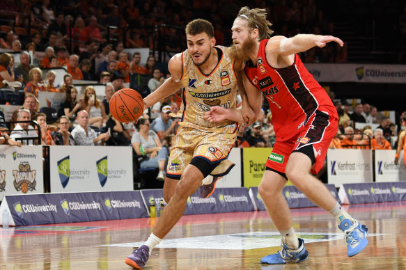 DJ Hogg of the Taipans
drives up court  under pressure from Brady Manek of the Wildcats.