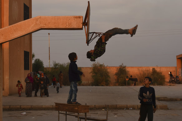 A child shows off his gymnastics skills at a high school full of people fleeing the fighting at the Syria-Turkey border.