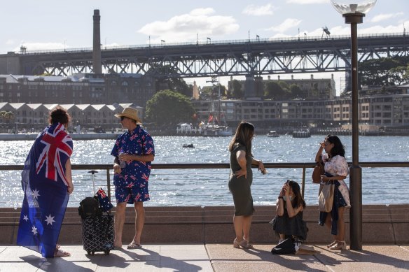 A man and woman dressed head to toe in Australian flags at the Australia Day festivities at Circular Quay in 2022.