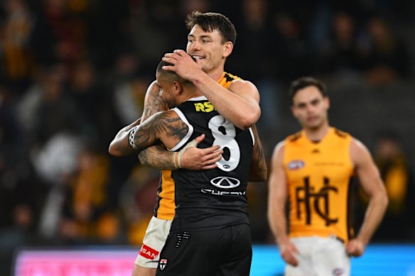 Josh Battle and former teammate Bradley Hill hug it out after the final siren.