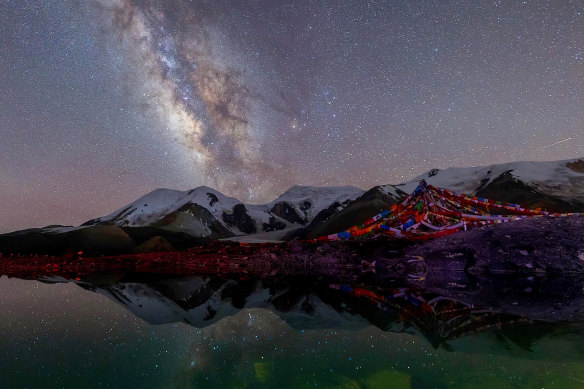 A shooting star lights up the night sky at the Amne Machin Snow Mountain in north-west China’s Qinghai Province on August 4.