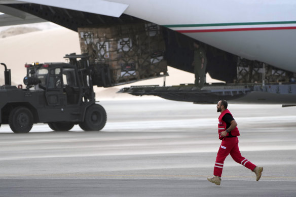 A Qatari Red Cross volunteer runs by a vehicle unloading humanitarian aid in Egypt late last week.